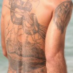800px-Man_with_tattoo_on_his_back_-_at_the_beach_-_cropped